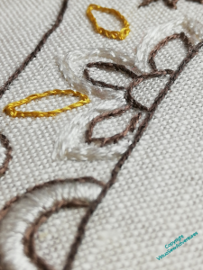 Oblique angle of the flower on Silkie's neck, showing the padding stitches in place.