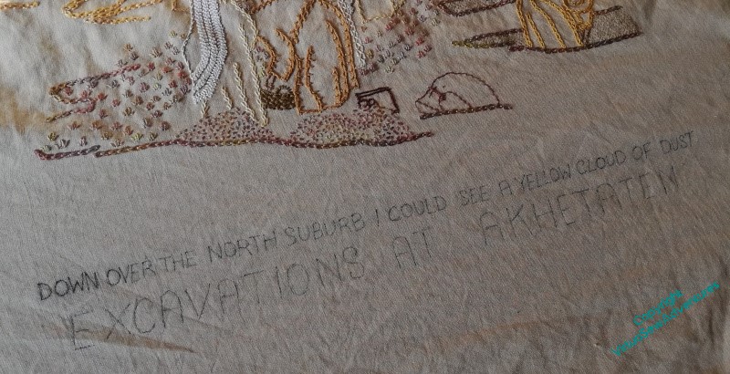 Close up of the text transferred onto the fabric: "Down over the north suburb I could see a yellow cloud of dust" in small capitals, and "Excavations at Akhetaten" in larger capitals
