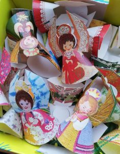 A box full of a tumble of cone-shaped paper angels.
