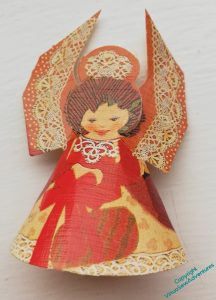 A single paper cone angel. The patterns looks as though they are textile based, because the wings have bobbin lace printed on them, and the necklace is from a piece of tatting.