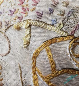 Close up of the same two workmen. The pale yellow braid stitch of the Difficult one is being unpicked. Sigh.