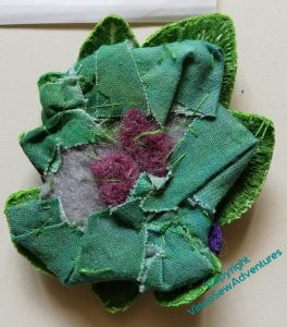 Back view of the Clump of Violets. It's a rther messy  tangle of stitches folded over a bit of felt padding