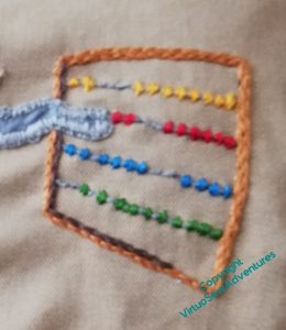 A Counting frame in stitchery, with beads of yellow, red, blue, and green. The mathstodon's trunk cank be seen manipulating the red row