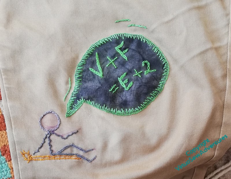 Finished patch of "V+F=E+2" in green on dark grey, with a grey stick figure speaking it.