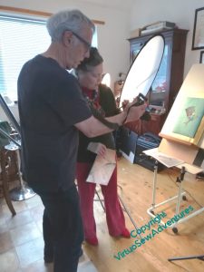 Bernard and Rachel poring over the display on his camera, with Nefertiti on the easel to be photographed.