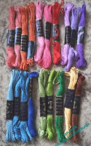 Two rows of brightly coloured, twisted cotton embroidery thread