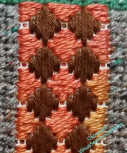 Stripe of block stitches in orange and brown