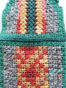 View of the back of the case (all mosaic stitch and the covering flap (mosaic stithc with coloured stripes of upright cross stitch) stitched together in green over the join.