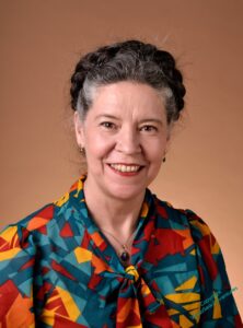 Photo of me, a white woman with dark hair, greying at the temples. I'm looking straight at the cameral with a smile