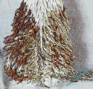 Close up of the stitching now all over the Cat's body. There is much entanglement of layers and stitches