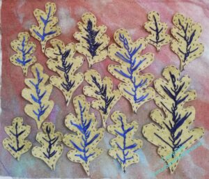Leaves now cut out and laid on a variegated fabric.